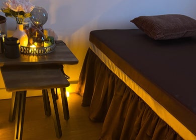 Tranquil massage room at Ve La Dee Thai Spa, Manchester, England, GB, with warm lighting and floral decor.