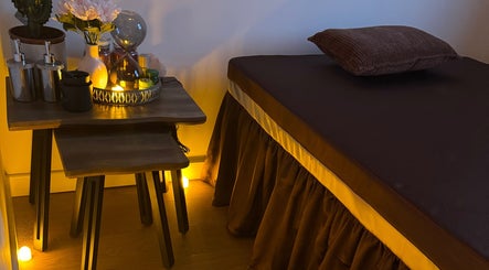 Tranquil massage room at Ve La Dee Thai Spa, Manchester, England, GB, with warm lighting and floral decor.