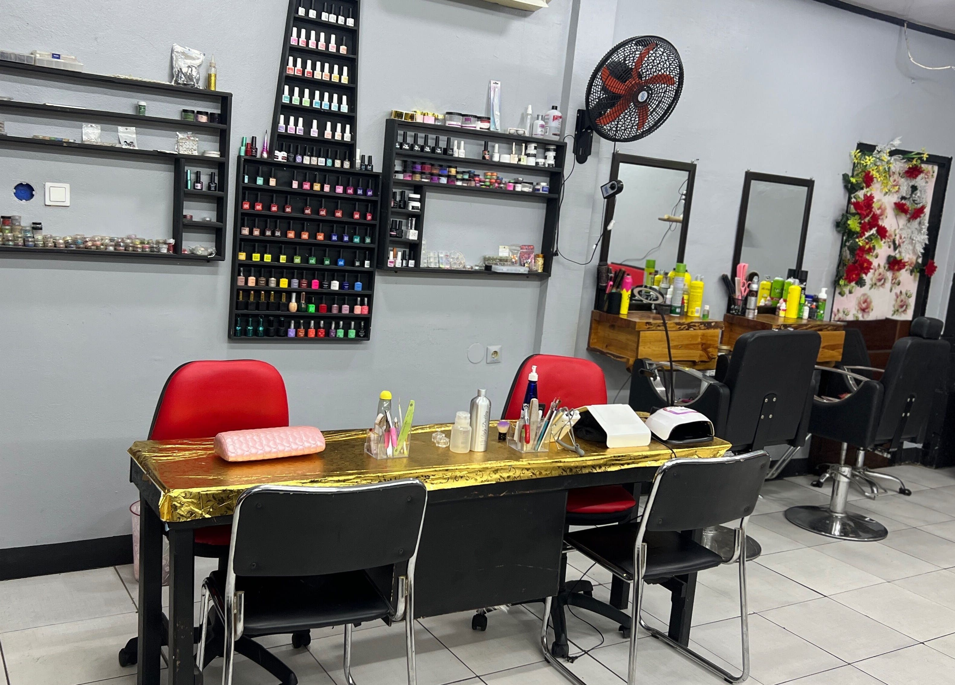 Interior of Stargirl Chel Beauty Salon in Paramaribo showcasing nail and hair stations.