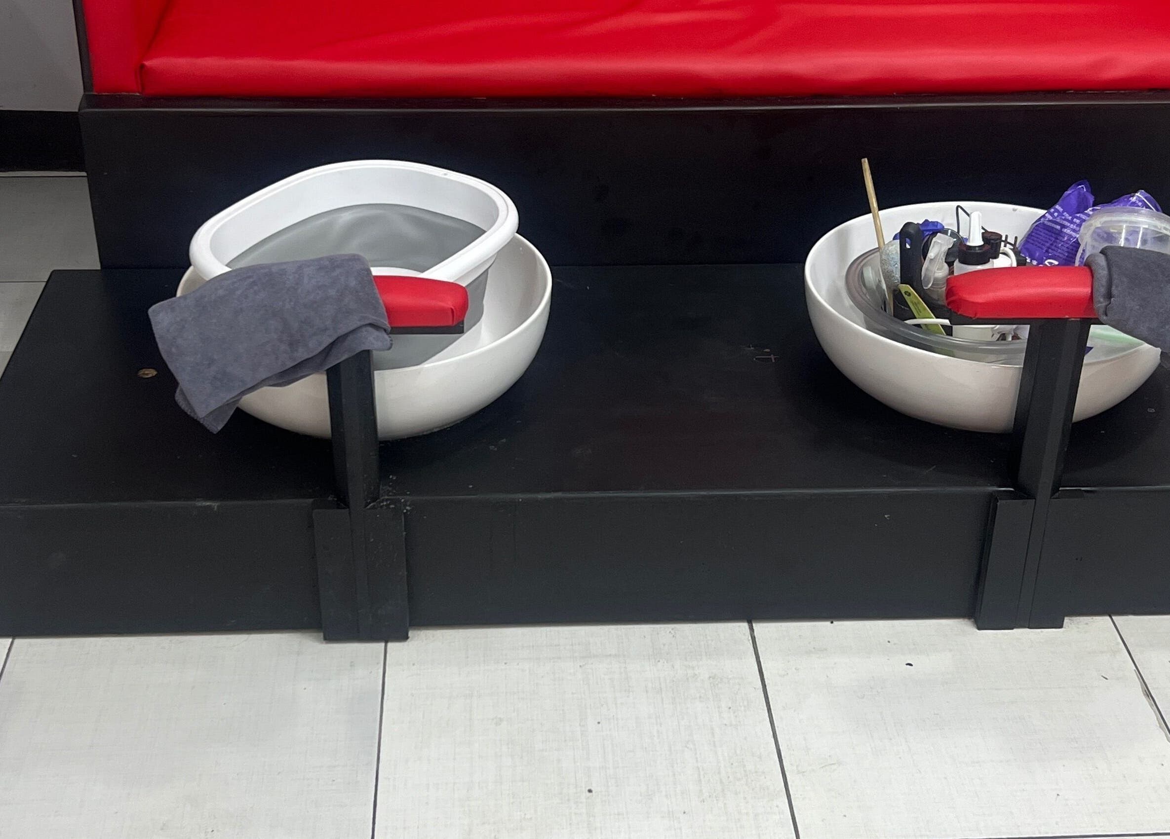 Pedicure spa bowls at Stargirl Chel Beauty Salon in Paramaribo, SR, featuring red seats and essential tools.
