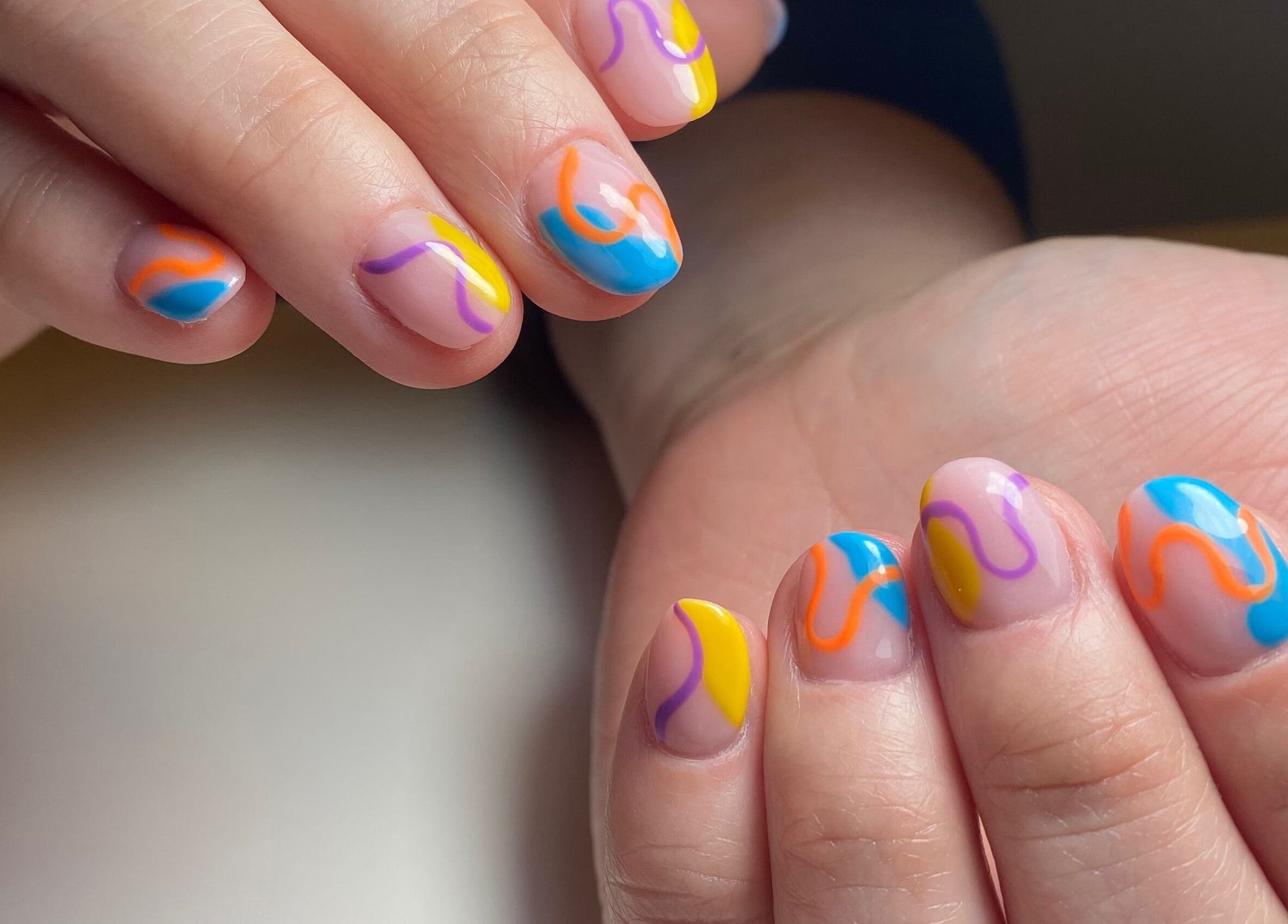 Colorful nail art at Isipinkbeauty, Ñuñoa, Región Metropolitana, CL, showcasing vibrant abstract designs.