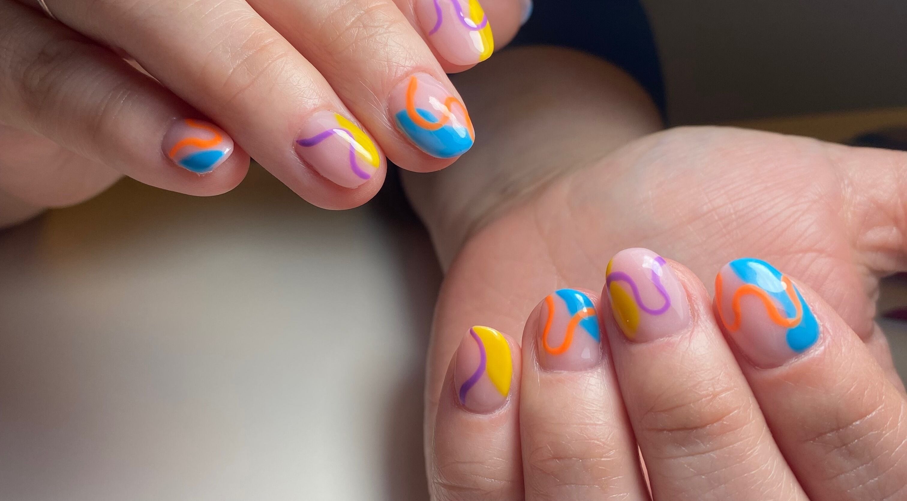Colorful nail art at Isipinkbeauty, Ñuñoa, Región Metropolitana, CL, showcasing vibrant abstract designs.