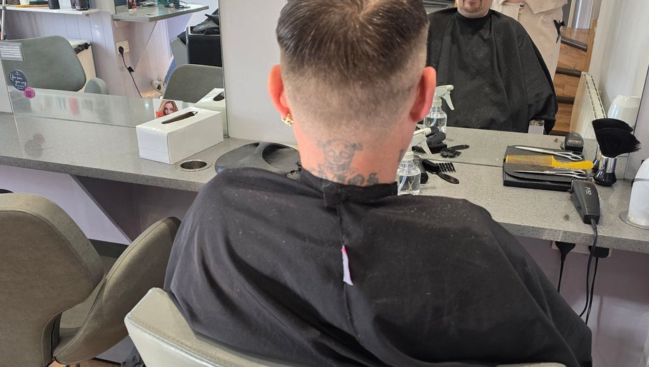 Stylish haircut at Kourtneys Lovely Locks, Newbury, England, GB. Modern salon interior with mirror reflection.