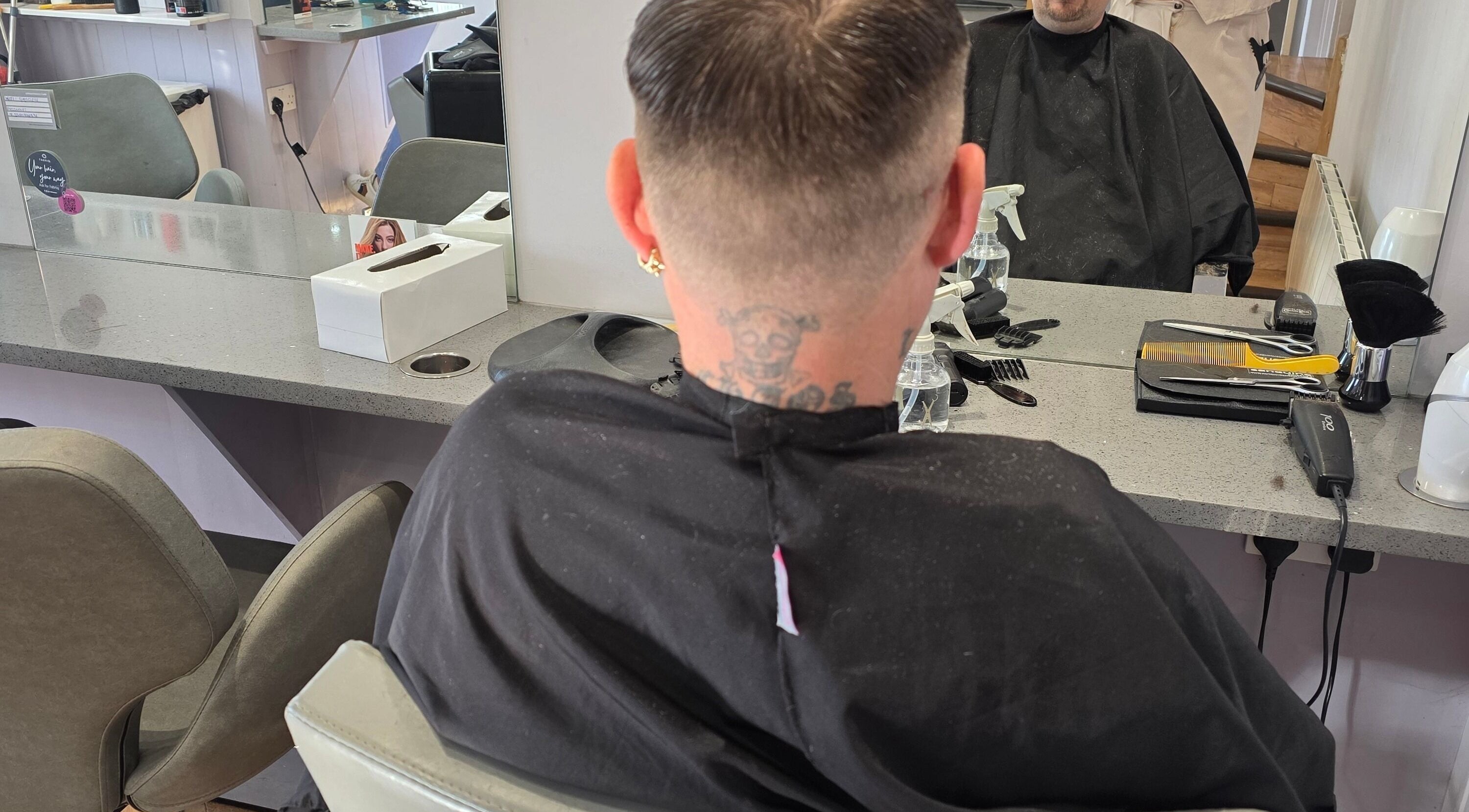 Stylish haircut at Kourtneys Lovely Locks, Newbury, England, GB. Modern salon interior with mirror reflection.