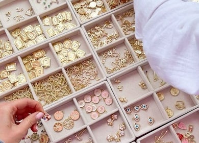 Assorted gold charms in a jewelry organizer at LINKED (Mobile Home Appointments UAE), Dubai, AE.
