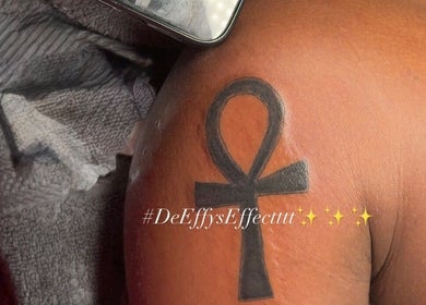 Ankh tattoo on shoulder at De Effys Effectttt, Ilford, England, GB showcasing professional ink work.