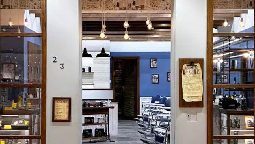 Ingresso accogliente di Il Barbiere Cremona a Cremona, Lombardia, IT con sedie classiche e illuminazione calda.