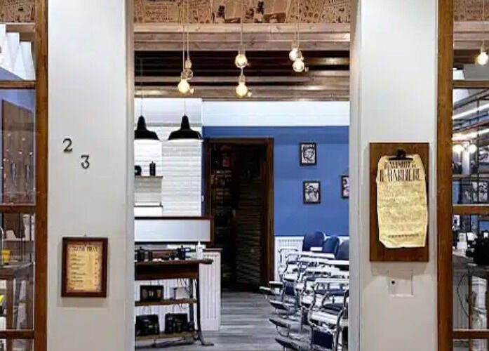 Ingresso accogliente di Il Barbiere Cremona a Cremona, Lombardia, IT con sedie classiche e illuminazione calda.