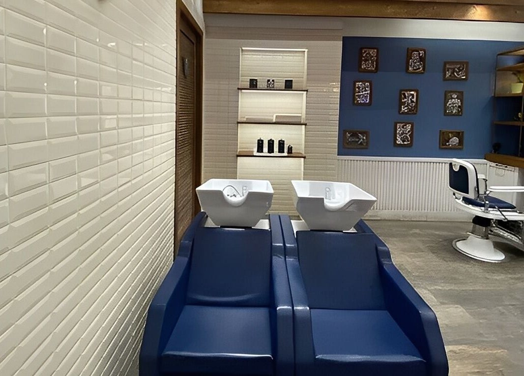 Interno elegante di Il Barbiere Giussano, Lombardia, IT con sedie moderne e lavabi bianchi.