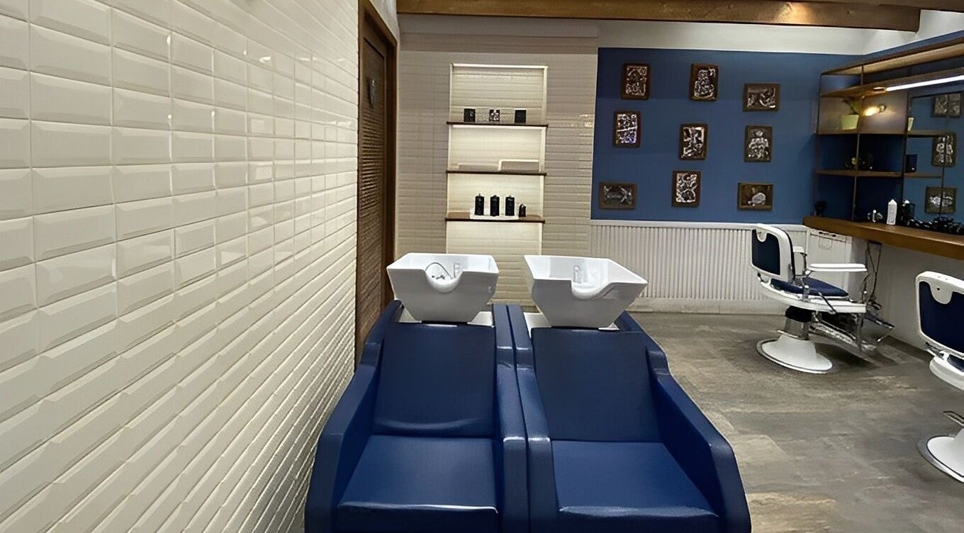 Interno elegante di Il Barbiere Giussano, Lombardia, IT con sedie moderne e lavabi bianchi.