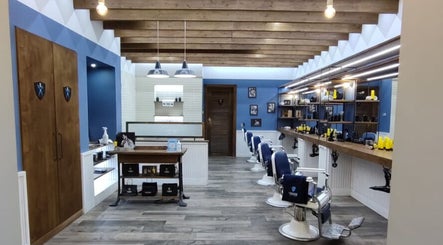 Interno moderno di Il Barbiere Busnago a Busnago, Lombardia, IT con sedie bianche e decorazioni in legno.