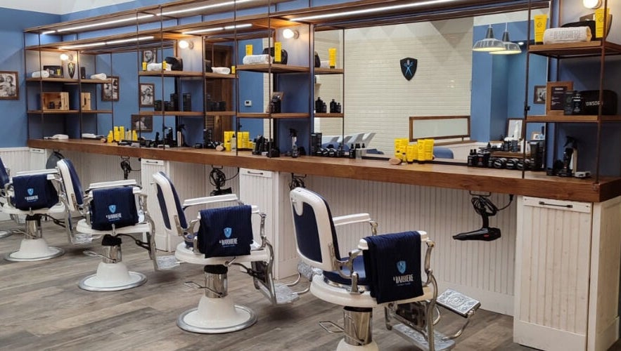 Interno di Il Barbiere Curno, Curno, Lombardia, IT: poltrone vintage e prodotti di bellezza in esposizione.