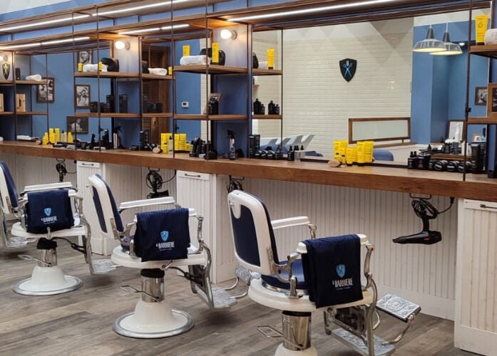 Interno di Il Barbiere Curno, Curno, Lombardia, IT: poltrone vintage e prodotti di bellezza in esposizione.