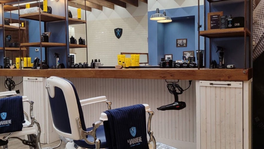 Interno classico di Il Barbiere Arese, Arese, Lombardia, IT, con sedie e prodotti di bellezza.