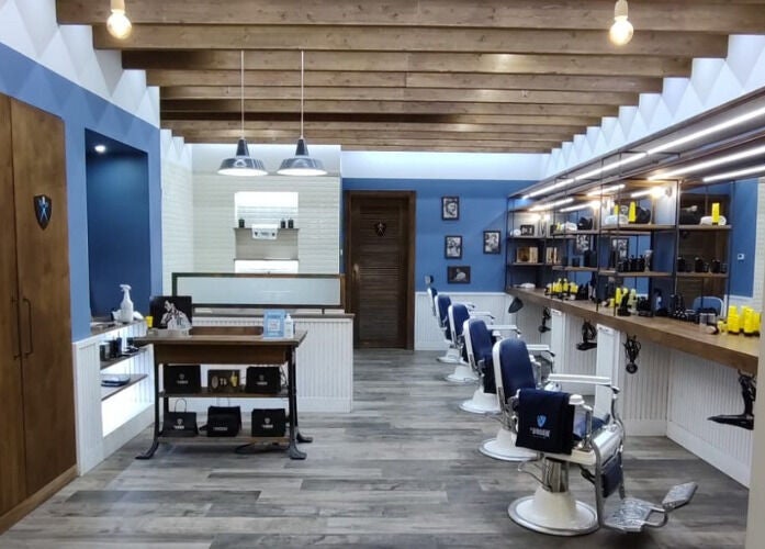 Interno di Il Barbiere Arese con sedie barberia e arredamento elegante in Arese, Lombardia, IT.