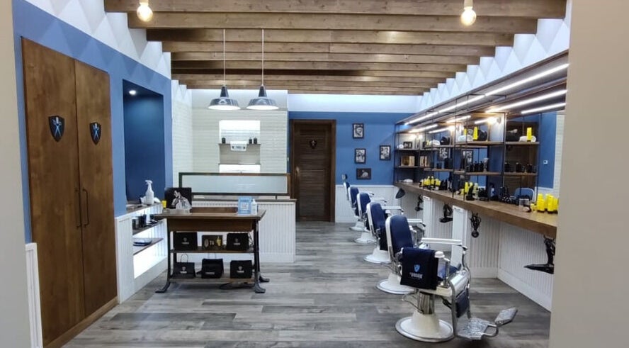 Interno di Il Barbiere Arese con sedie barberia e arredamento elegante in Arese, Lombardia, IT.