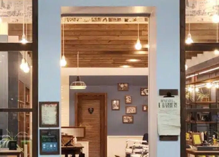 Interno vintage di Il Barbiere Carugate, Carugate, Lombardia, IT con illuminazione calda e arredamento elegante.