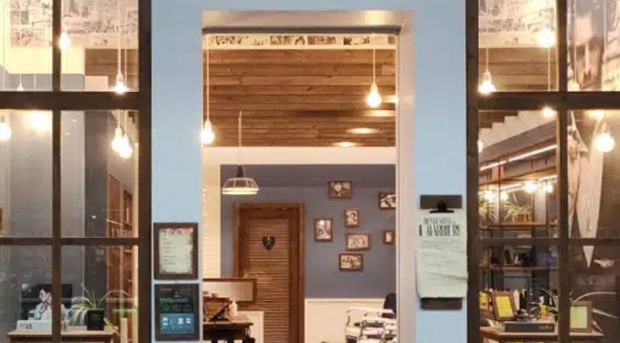 Interno vintage di Il Barbiere Carugate, Carugate, Lombardia, IT con illuminazione calda e arredamento elegante.