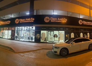 Night view of Glam & Go Ladies Salon L.L.C, Dubai, Dubai, AE, with illuminated signage and parked cars.
