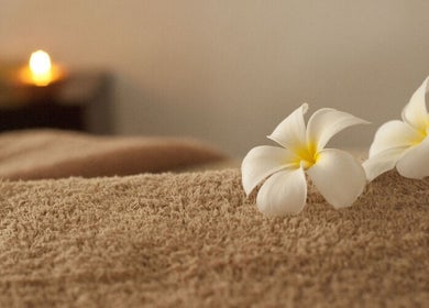 Plumeria flowers on a massage table at JY Aromatherapy, Bayan Lepas, Penang, MY, evoking relaxation and tranquility.