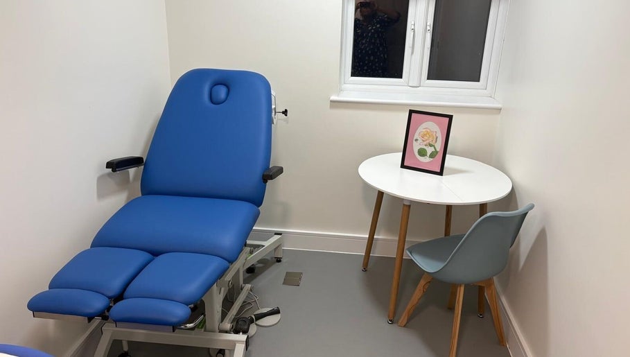 Comfortable massage room at Alina N. Sports Massage in Barnet, England, featuring a blue treatment bed and modern decor.