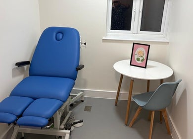 Comfortable massage room at Alina N. Sports Massage in Barnet, England, featuring a blue treatment bed and modern decor.