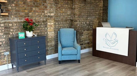 Inviting waiting area at Alina N. Sports Massage, Barnet, England, GB featuring a chair, table, and desk.