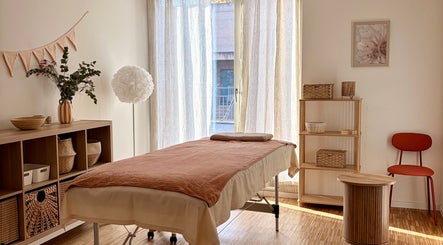Salle de traitement paisible à Flower Studio, Corsier, Genève, CH, avec éclairage naturel et décor chaleureux.