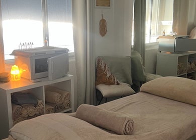 Cozy treatment room at IPL Aesthetics - Bundall, Bundall, Queensland, AU with warm lighting and towel setup.