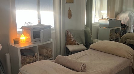 Cozy treatment room at IPL Aesthetics - Bundall, Bundall, Queensland, AU with warm lighting and towel setup.