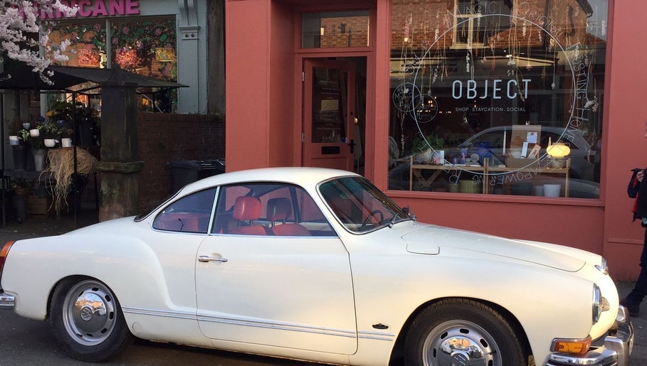 A classic white car parked in front of Wardrobe Of Friends in Stockport, England, GB, showcasing the venue's exterior.