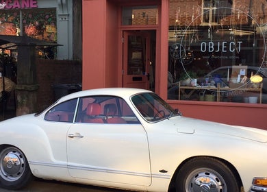A classic white car parked in front of Wardrobe Of Friends in Stockport, England, GB, showcasing the venue's exterior.