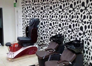 Modern salon seating at Mina Kokosh, Glasgow, Scotland, GB, featuring bold black and white wall design.