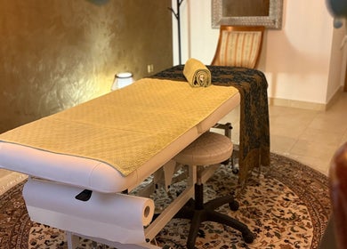 Ugodna masažna soba u Thaka's Touch, Zagreb, Grad Zagreb, HR s elegantnim stolom i osvijetljenim ambijentom.
