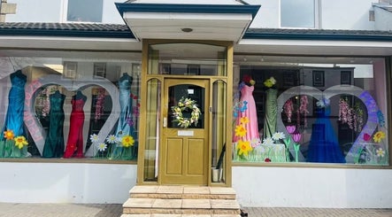 Colorful dresses in Pure Glow's Carlisle, England window display highlighting beauty and fashion.
