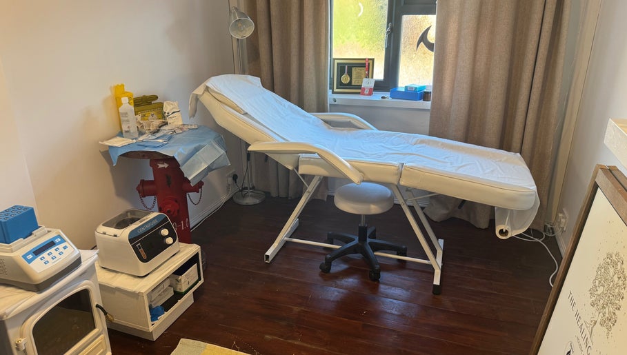 Treatment room at The Healing Place Global LTD, Taverham, England, featuring a comfy bed and serene decor.