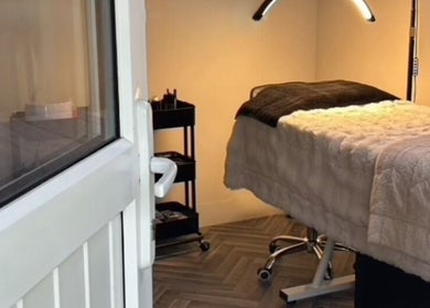 Cozy treatment room at E.N Beauty, Preston, England, GB, featuring a warm-lit massage bed and equipment.