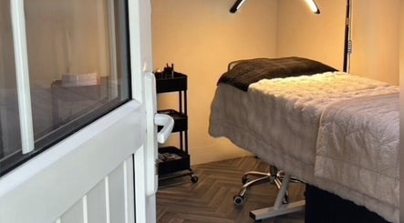 Cozy treatment room at E.N Beauty, Preston, England, GB, featuring a warm-lit massage bed and equipment.