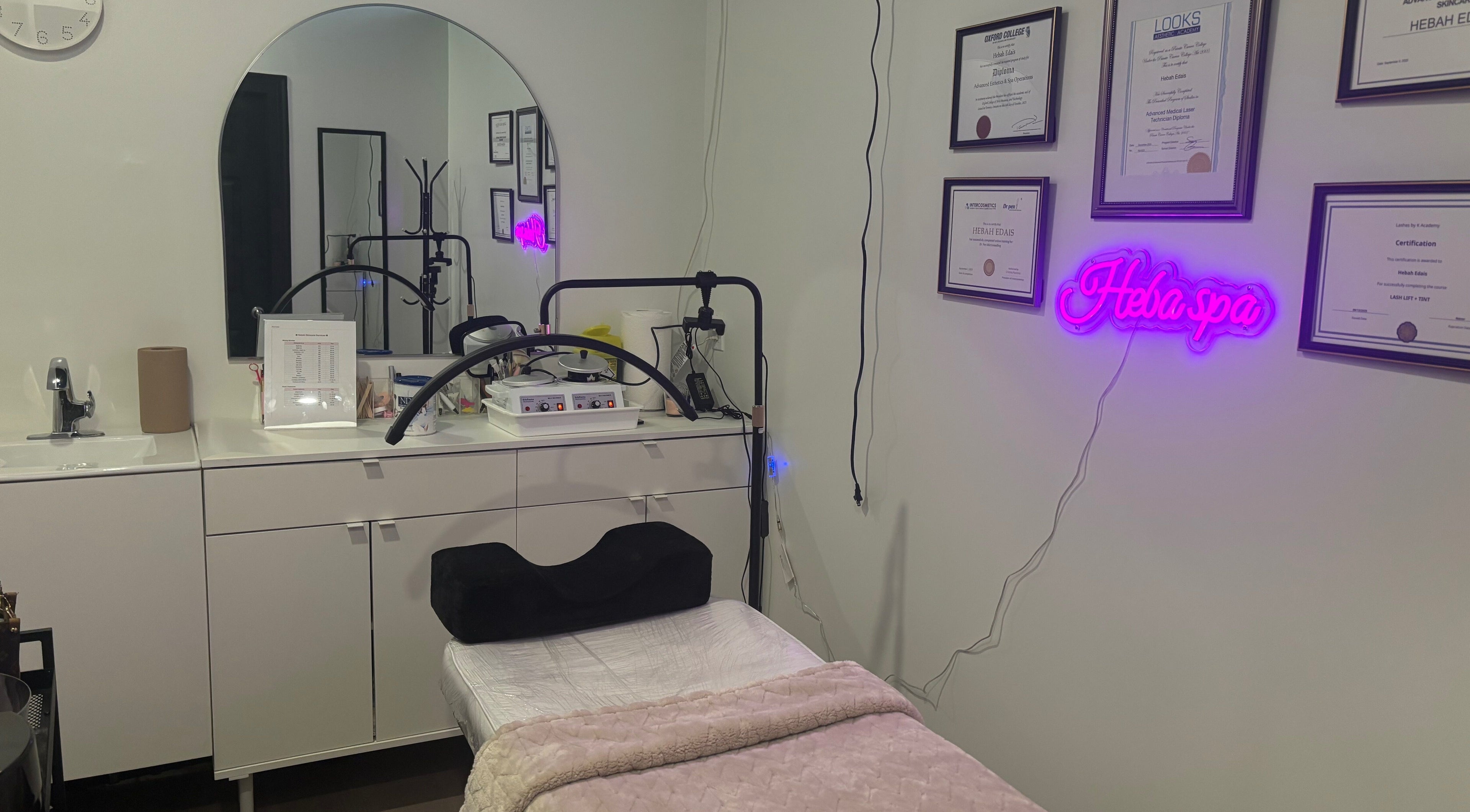 Serene interior of Hebah Skin Care in Newmarket, Ontario, CA showcasing treatment bed, certificates, and decor.
