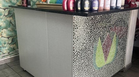 Sleek reception desk at Sheckies Hair, Cape Town, Western Cape, ZA with stylish mosaic design and hair products.