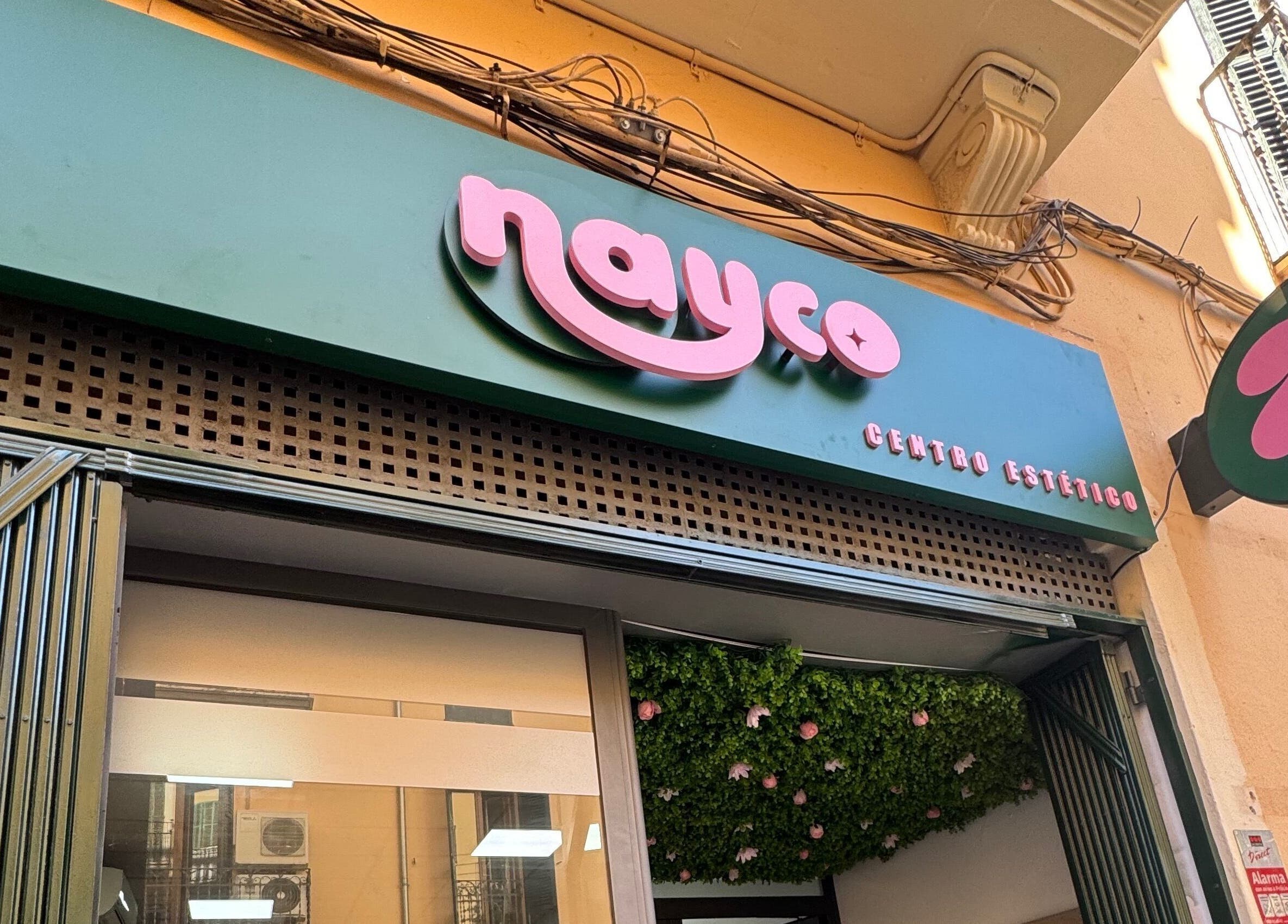 Entrada de Nayco Centro Estético en Palma, Illes Balears, ES con letrero verde y letras rosas.
