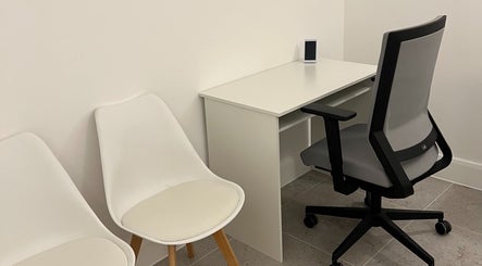 Modern seating area at AtelieRx Medical Aesthetics, St Albans, England, GB, with sleek chairs and desk.