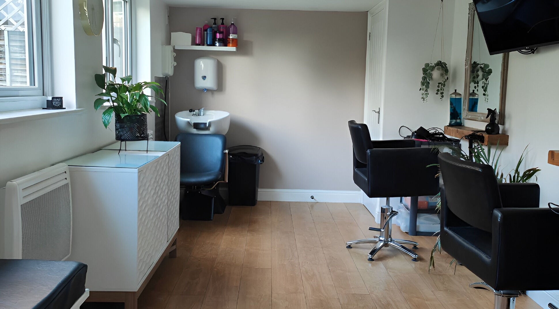 Interior of Little Rasberrys Hair Studio, Norwich, England, showcasing stylish chairs and decor.
