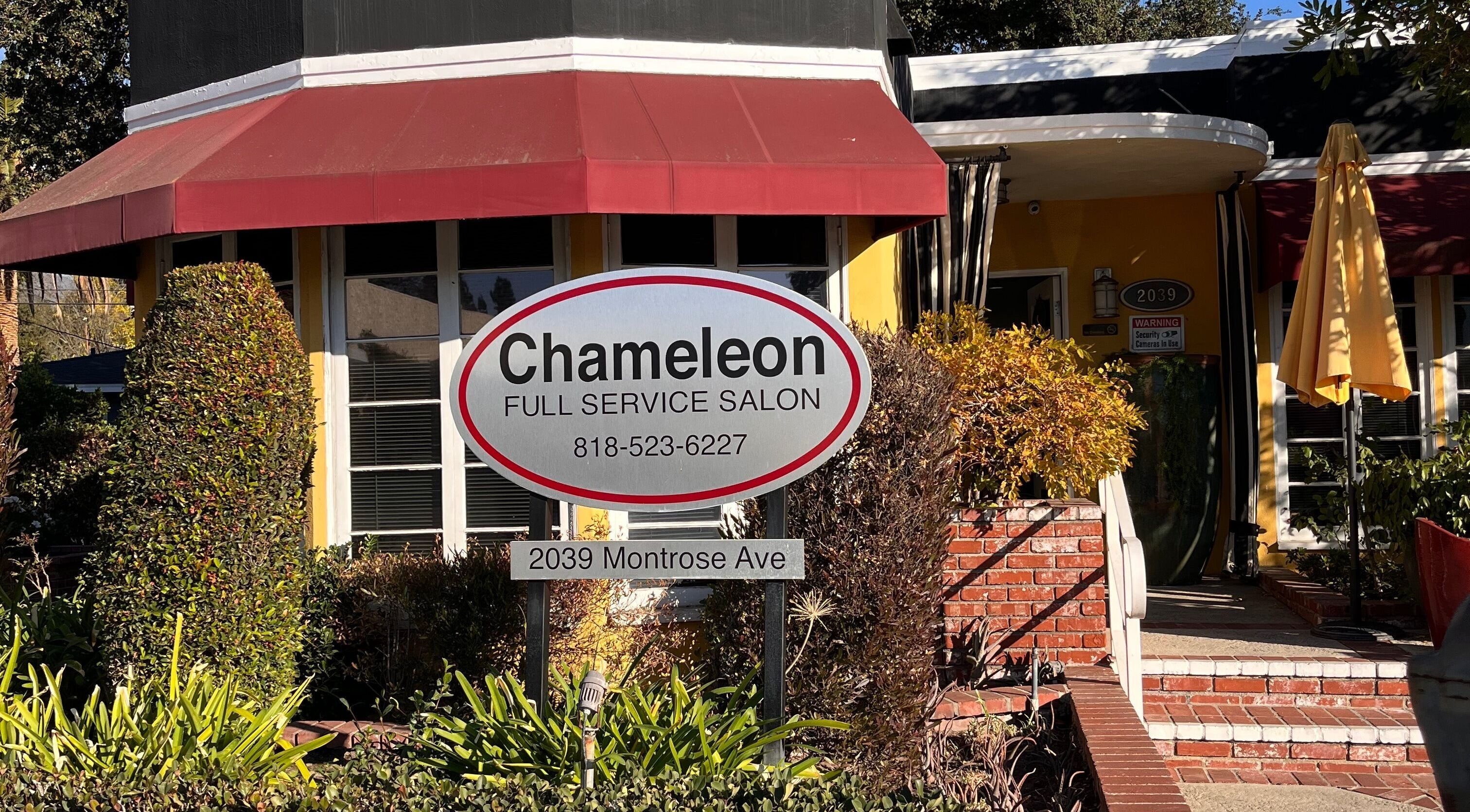 Entrance of Chameleon Beauty Salon at La Crescenta-Montrose, California, US, with a welcoming sign and lush greenery.