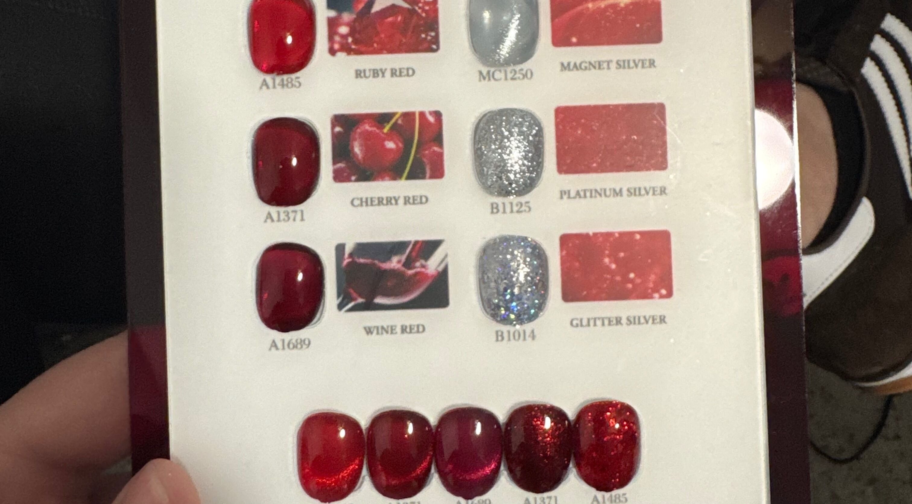 Muestra de esmaltes en tonos rojos y plateados en Nails by Mel, Miami, Florida, US.