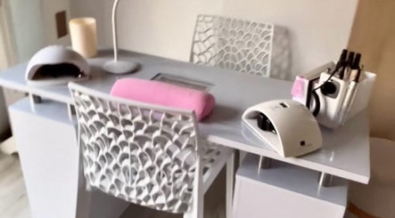 Élégant espace manucure à Shel Nails19, Marseillan, Occitanie, FR. Lampe, coussin rose et outils bien organisés.