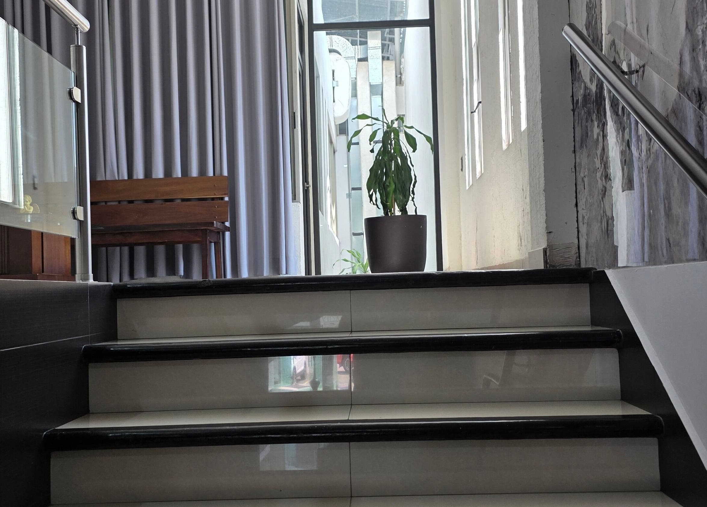 Escalera moderna en EDUARDO ESCOBAR ORTODONCIA, Los Reyes De Salgado, Michoacán, MX, con planta decorativa.