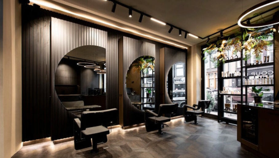 Modern interior of Hairsalon Coup D'état, Amsterdam, NL with sleek styling chairs and elegant decor.