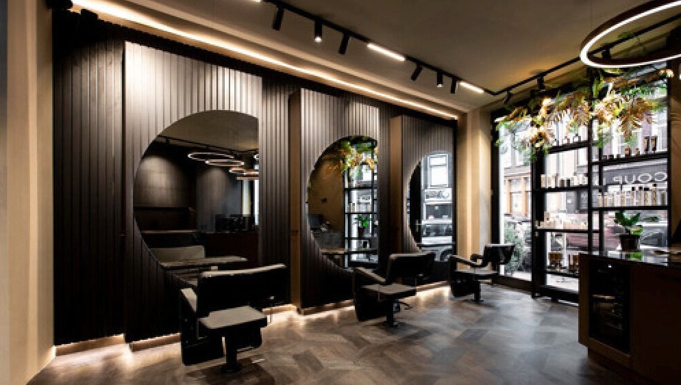 Modern interior of Hairsalon Coup D'état, Amsterdam, NL with sleek styling chairs and elegant decor.