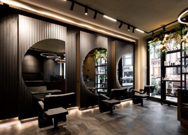 Modern interior of Hairsalon Coup D'état, Amsterdam, NL with sleek styling chairs and elegant decor.